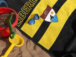 mockup-of-a-towel-lying-on-the-beach-with-accessories-near-it-and-sunglasses-a14892